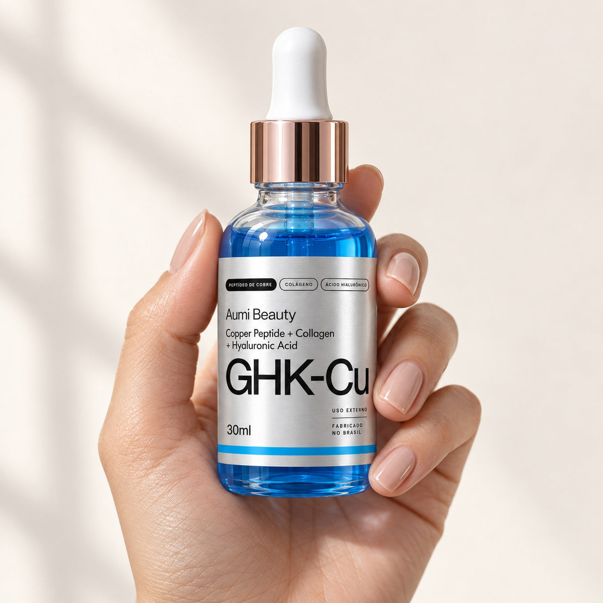 Mão segurando o frasco do Sérum GHK-Cu Aumi Beauty
